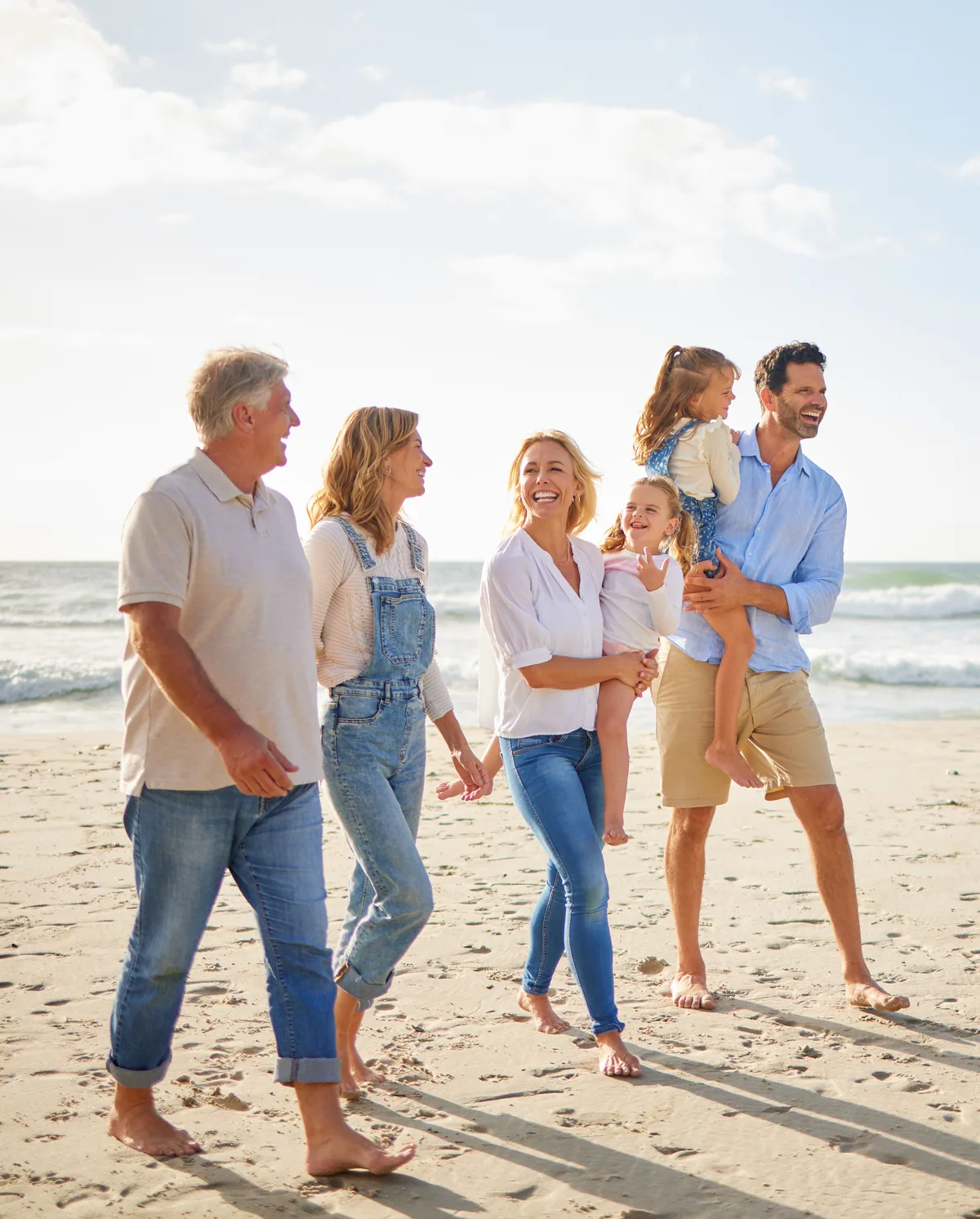 Three generations of a family walking together along a beach